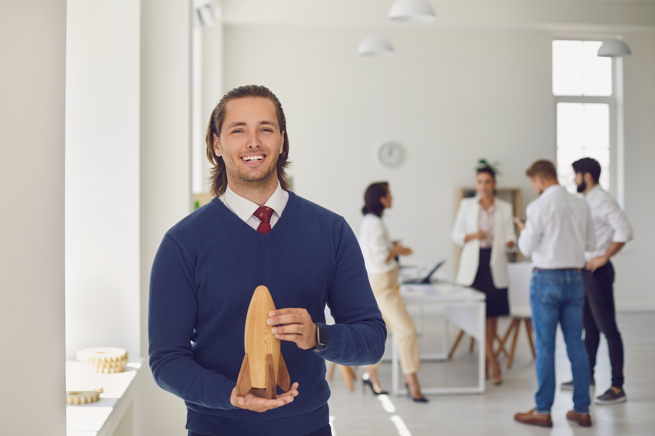 Happy Company Owner Looking at Camera Holding Toy Rocket as Symbol of New Business Start-up