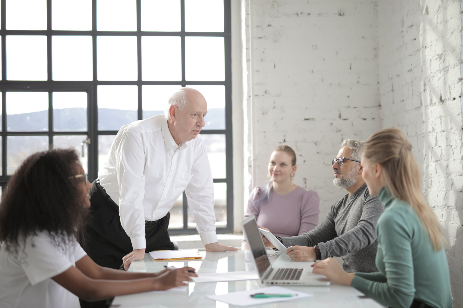 Cheerful boss explaining information to colleague in office
