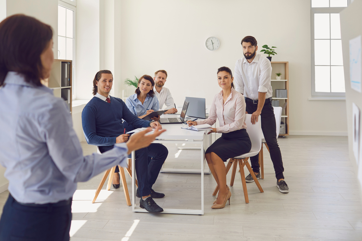 Group of Business People in Office Looking at Woman Colleague Presenting New Project or Startup Idea