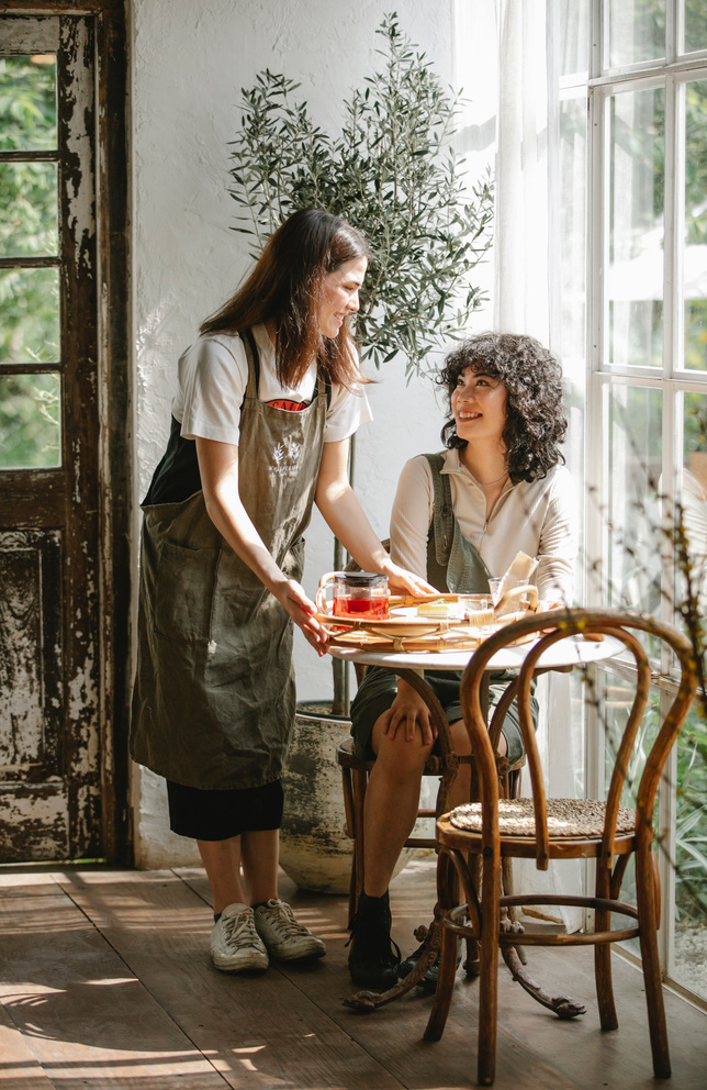 Positive waitress and client in cafe