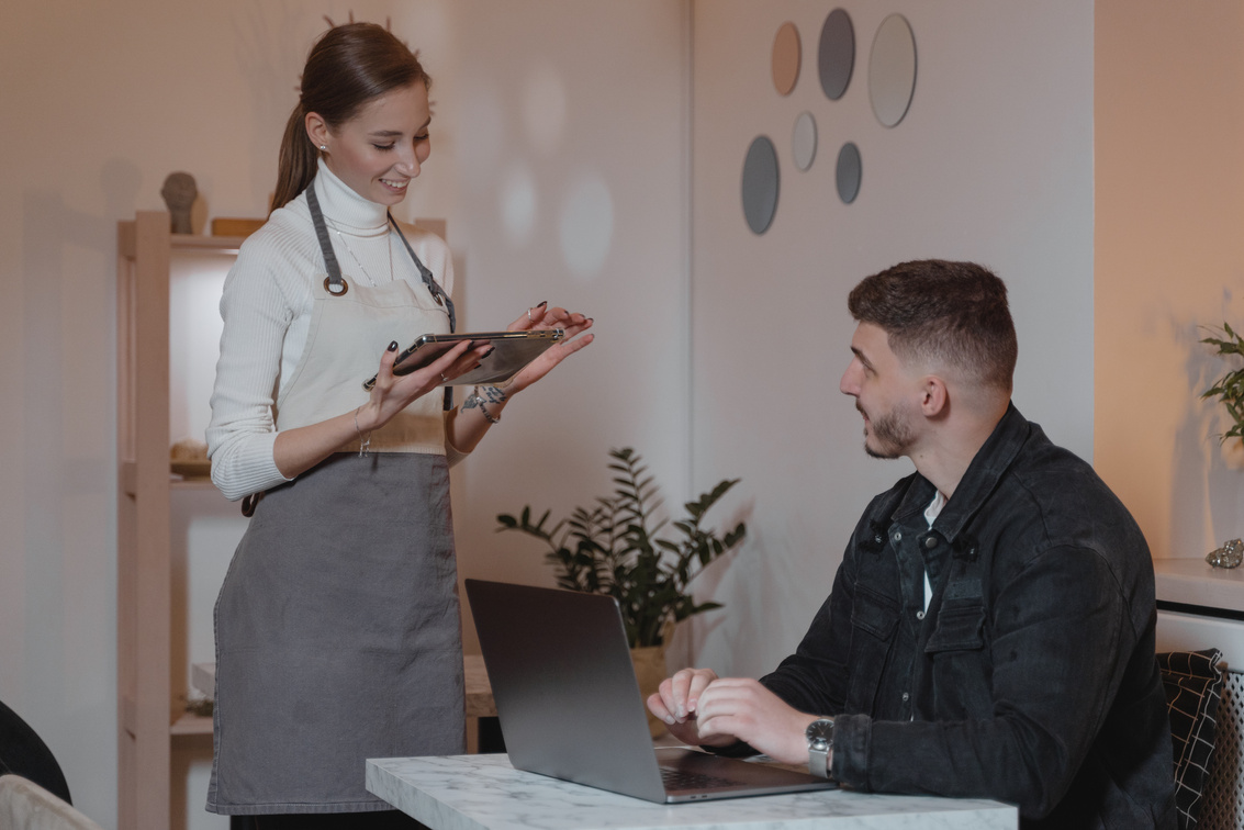 A Waitress Talking to a Customer at a Restaurant